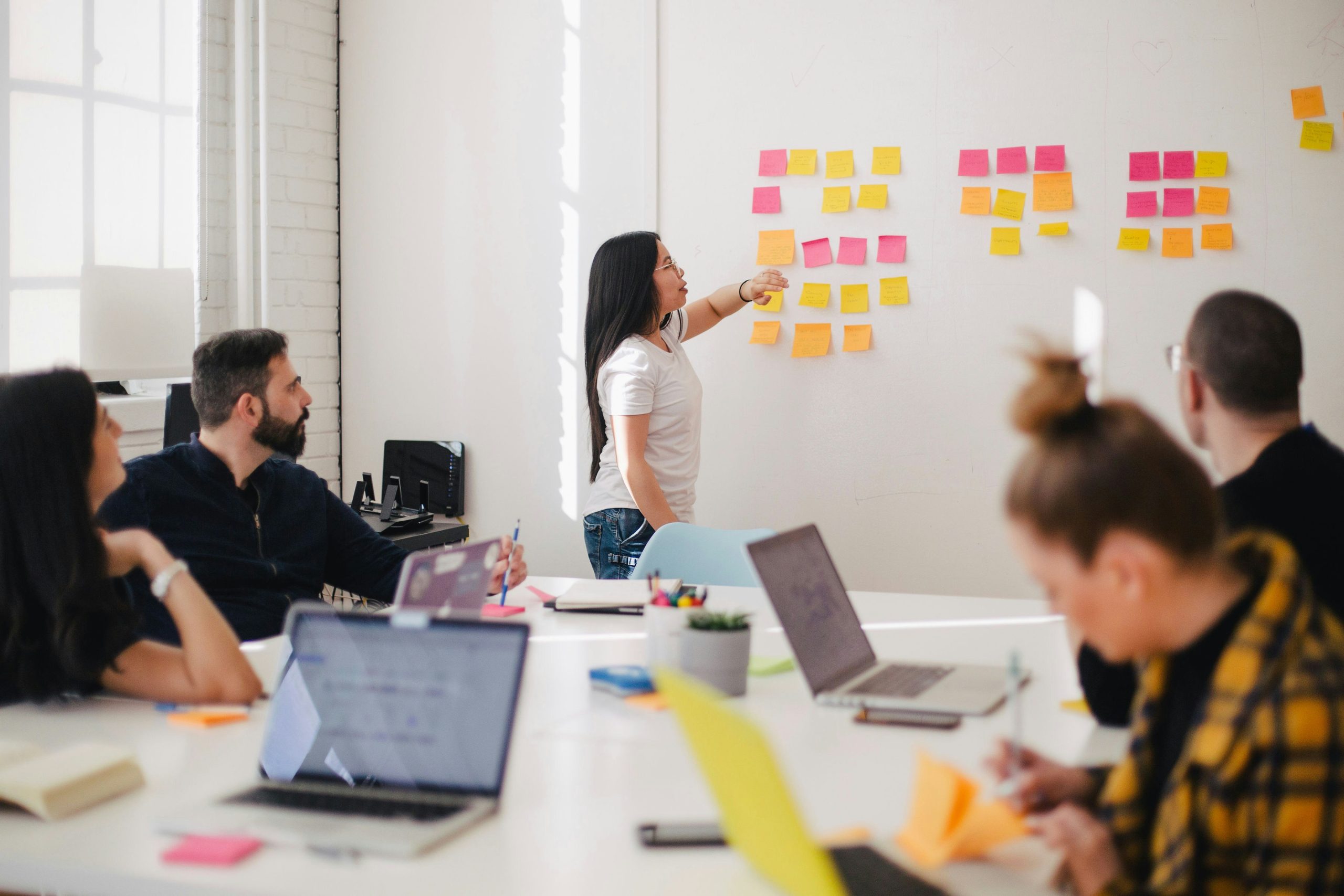équipe en réunion, travaillant sur un projet, ajoutant des post-it sur un tableau